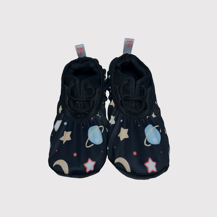 front view of shoe covers, black fabric with planets pattern