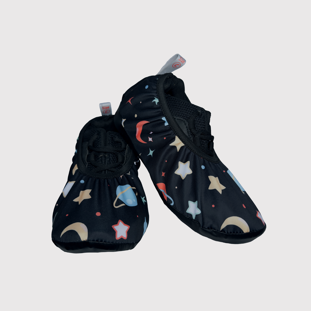 front view of shoe covers, black fabric with planets pattern